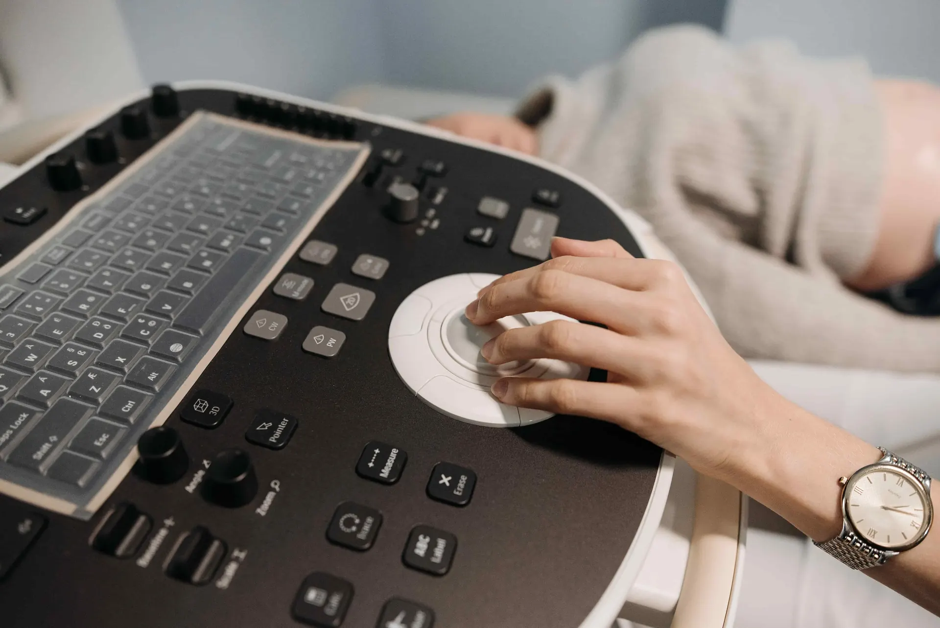 Sonographer's hand on the controls of an ultrasound system